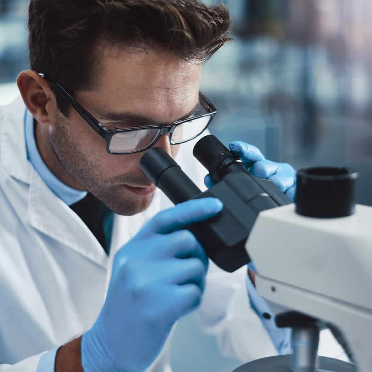 Doctor looking through microscope